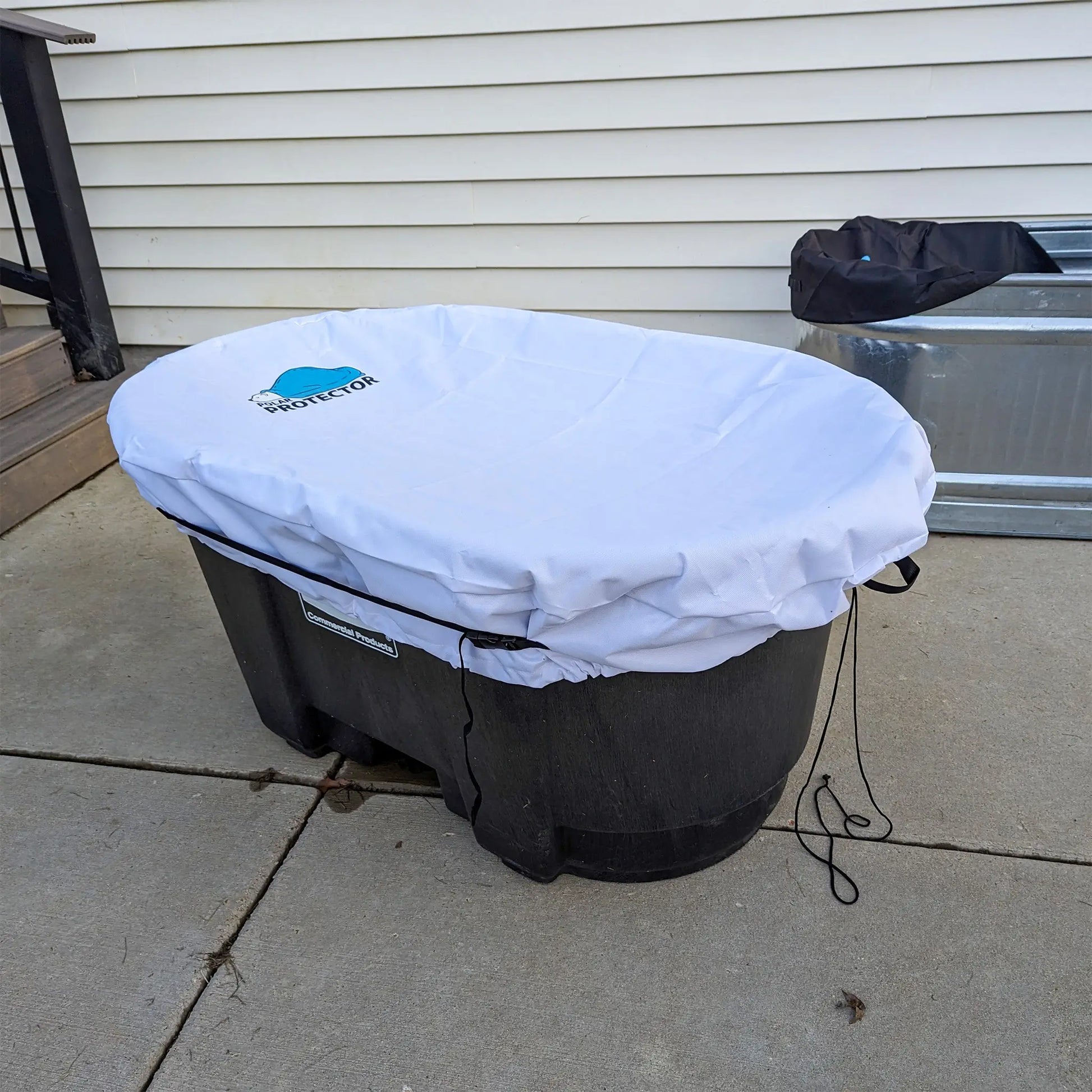 In use image of a white Polar Protector cold plunge stock tank cover being used on a stock tank outside.