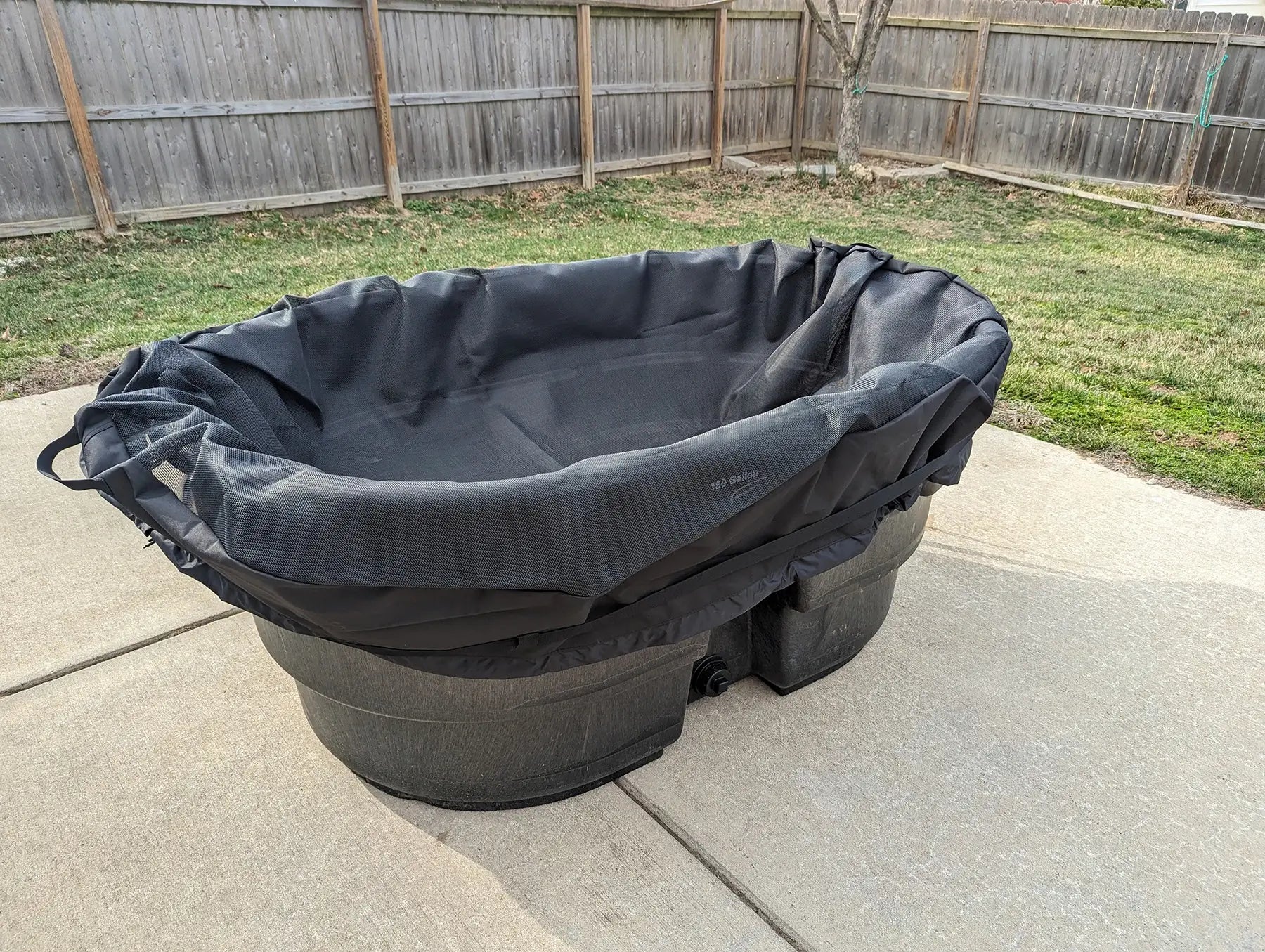 In-use image of a mesh stock tank cover for 100-gallon stock tank. The mesh cover keeps leaves and bugs out of your water.